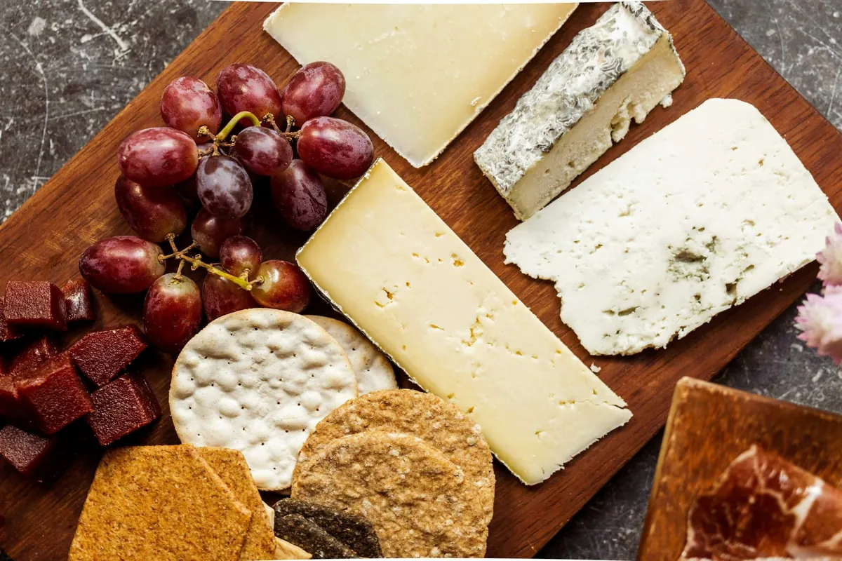 Wedges of aged hard, soft and blue cheese with grapes and crackers