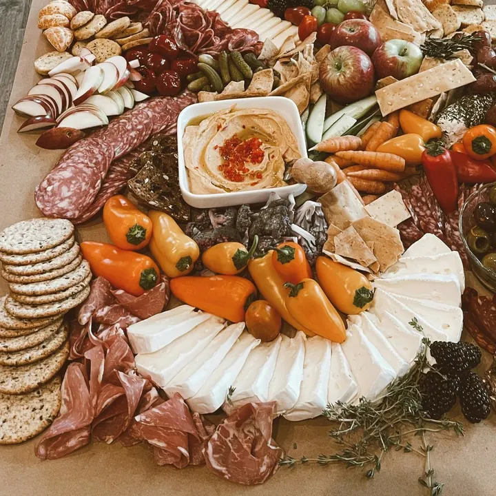 Cured meats, crackers and soft cheese laid out on a long grazing table