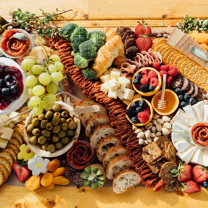 A full charcuterie spread with fruit, bread, dips and cured meats